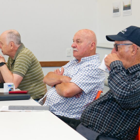 TADSA members sit around the table on chairs for a meeting.